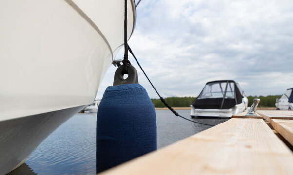 Boat with blue fenders docked at a pier