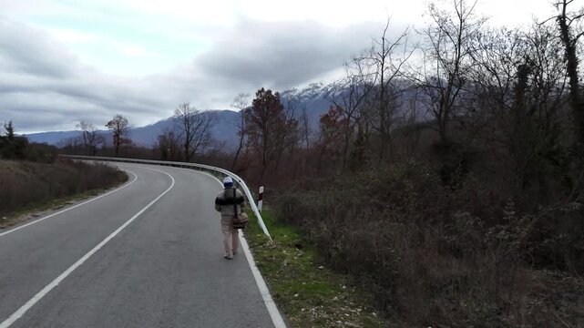 DIY Destinations host Charles Huang walks along a deserted mountain road through the border zone between North Macedonia and Albania