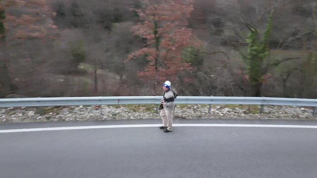 DIY Destinations host Charles Huang walks along a deserted mountain road through the border zone between North Macedonia and Albania