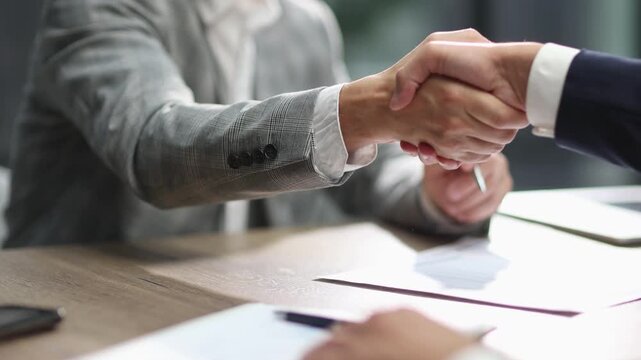 Businessman gestures while holding pen, engaged in meeting