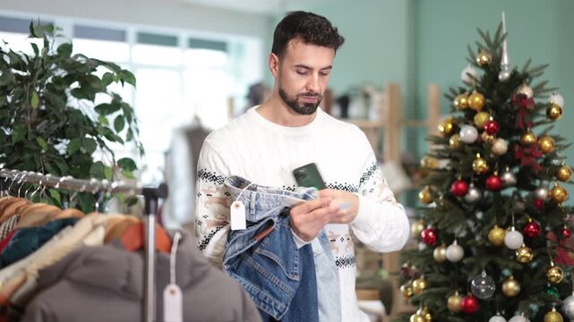 X Mass shopping, Male customer scans QR code on jeans label, activates discount code, registers purchase in clients personal account, verifies quality certificate