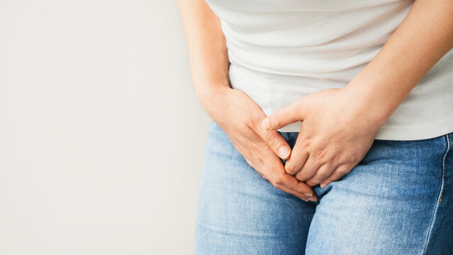 Young woman holding her groin