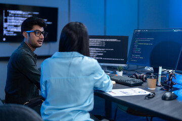 Professional IT specialist and programmer working on software development, Male developer talking with female colleague about computer code, Modern coding team and technology collaboration concept © Art_Photo