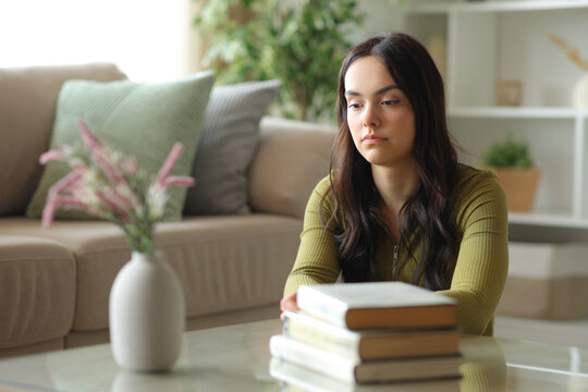 Distracted young woman thinking with lost look at home