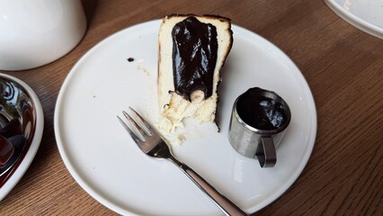 Obraz premium Top view of San Sebastian burnt Basque cheesecake slice with chocolate sauce on a plate