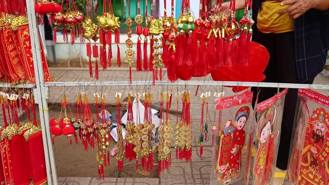 Traditional Vietnamese Lunar New Year decoration close up. Street market counter with red scrolls, feng shui charms and lucky paper ornaments for sale before Tet holiday in Nha Trang, Vietnam.