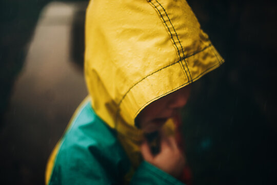 Boy In Yellow Raincoat Standing in rain