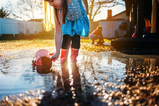 Girl Playing in Rain Puddle with Backlight