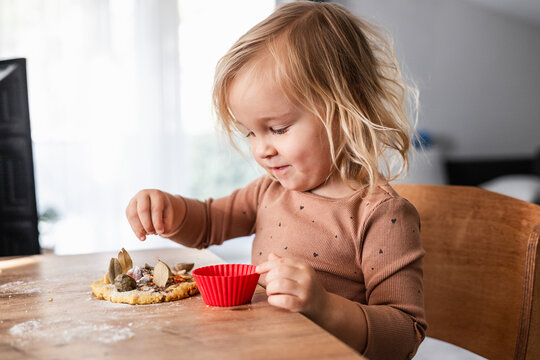 Toddler girl sensory playing with natural craft materials