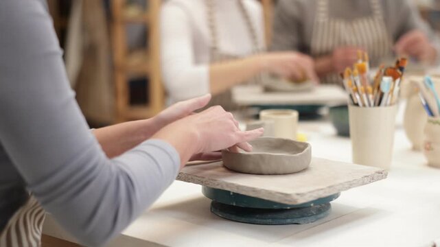 Closeup of female hands sculpting at a table in a pottery studio. High quality 4k footage
