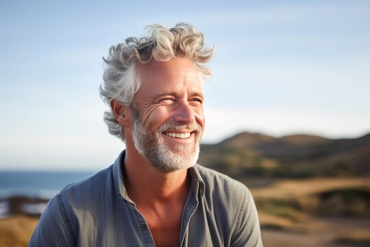 Handsome mature man with grey hair and beard enjoying sunny day