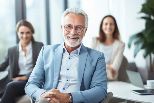 Senior businessman smiling, posing for a portrait with his professional team in a modern office