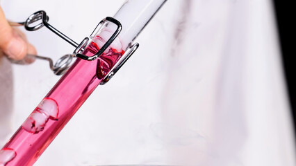 Naklejka premium Close Up of Pink Liquid Reacting with Smoke in Laboratory Test Tube
