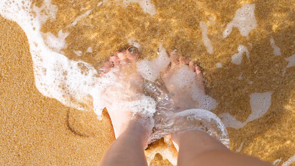 Fototapeta premium Bare Feet Standing in Ocean Waves on Sandy Mai Khao Beach