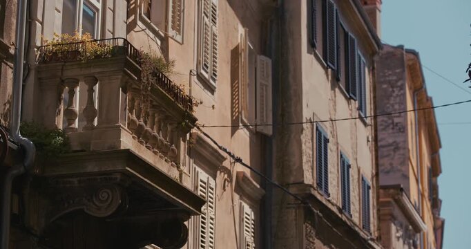 Balcony and window shutters on building facades along Sergius Street.