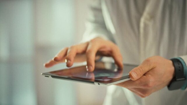 In a clinical imaging suite, a medic holds an electronic gadget, scaling a panoramic x-ray on its screen to scrutinize pathological zones, ensuring precise diagnosis with focused attention