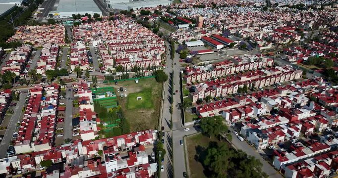 High-altitude drone shot of a middle-class neighborhood in the Mexico City metropolitan area during a sunny day. Residential blocks and urban layout define the scene.