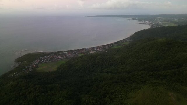 Scenic aerial flyover of Cabugao Bay in Catanduanes, Bicol, Philippines with tropical coastline and forested mountain terrain