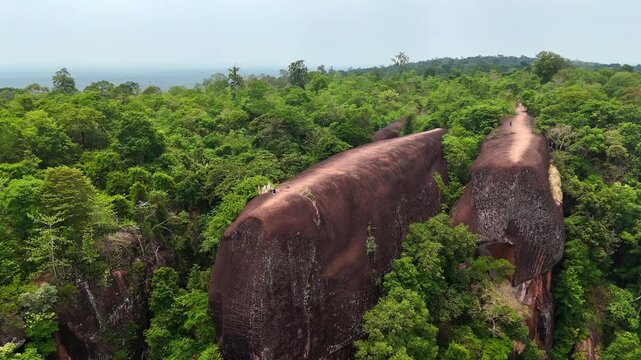 Aerial orbit around the Three Whale Rocks in Thailand, massive sandstone whale-like shapes in dense tropical highlands