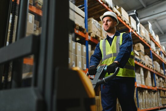 Portrait of a handsome warehouse worker in overalls and a helmet