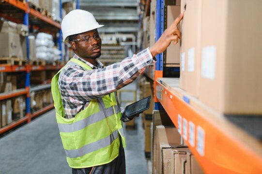 Portrait of a handsome african american warehouse worker in overalls and a helmet