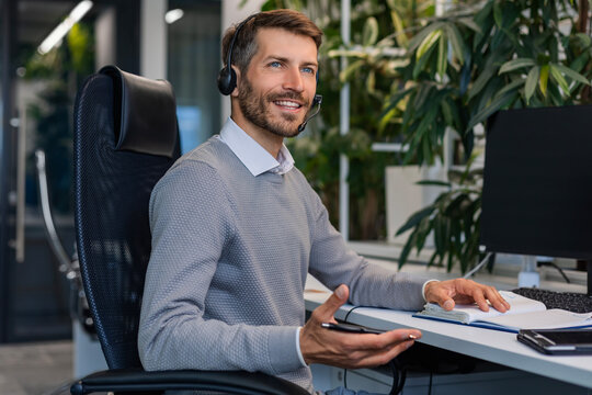 Smiling friendly handsome young male call centre operator.
