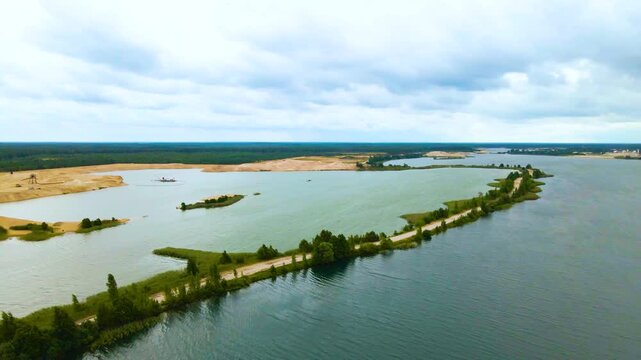 Aerial View Flying over a Vast Sand Quarry with Artificial Lakes and a Green Forest