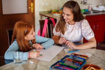 Fototapeta premium Mother helping daughter with art project for school
