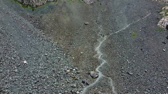High angle view of winding zig-zag hiking trail on steep rocky mountain slope, trekking challenge, Ala-Kul, Kyrgyzstan. High quality 4k footage