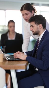 Supportive woman executive guiding male employee during collaborative business project in bright corporate workspace. High quality 4k footage