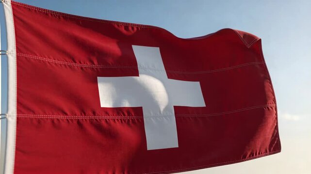 Waving red flag with centered white cross billowing at shore in breeze showing hoist seam stitching