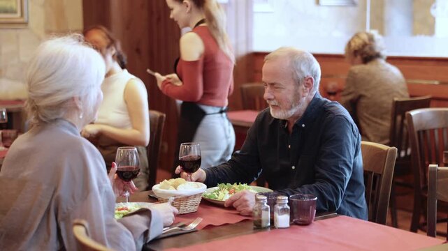 Mature couple communicate and chatting during date in cafe, have rendezvous, lovers tryst. Participants of meeting get to know each other, joke and communicate during meeting 