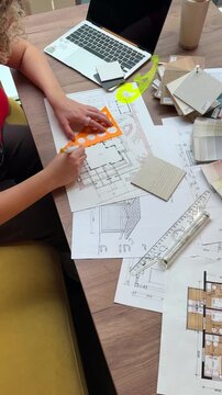 Architect workspace, hands reviewing residential blueprint with ruler, material samples and laptop, architectural planning, renovation design and house project concept.