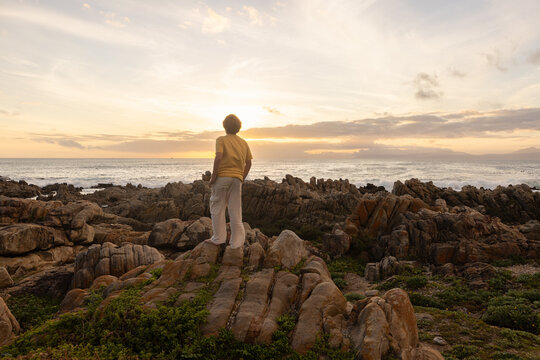 young boy exploring  rocky coastline of DeKelders, Gansbaai, South Africa