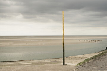 Piquet jaune sur paysage de mer et ciel tourmenté à Berck-sur-Mer dans le Pas-de-Calais en France © Pause Papote