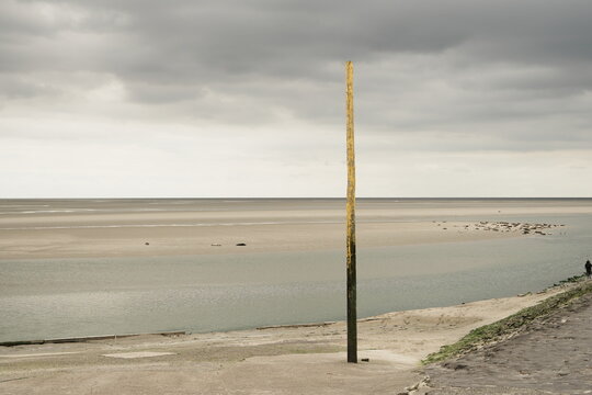 Piquet jaune sur paysage de mer et ciel tourment&eacute; &agrave; Berck-sur-Mer dans le Pas-de-Calais en France