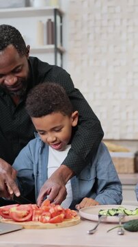 A diverse family is happily preparing a healthy meal together in a modern kitchen, learning culinary skills