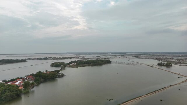 Top down aerial view of coastal fish ponds and road in Indonesia