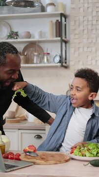 A diverse family enjoys preparing a healthy meal together in a bright, modern kitchen, sharing laughter and food