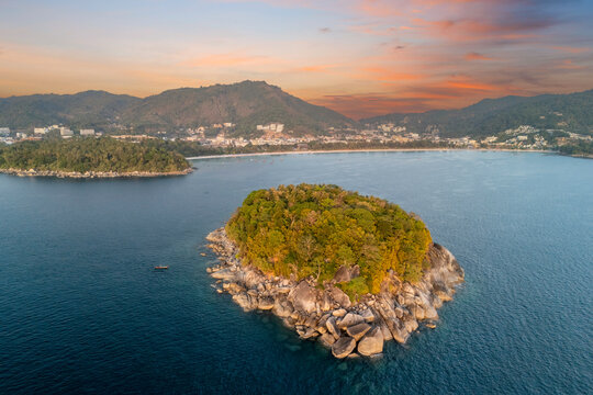 Aerial view of a verdant island with a rocky shore in Phuket, Thailand