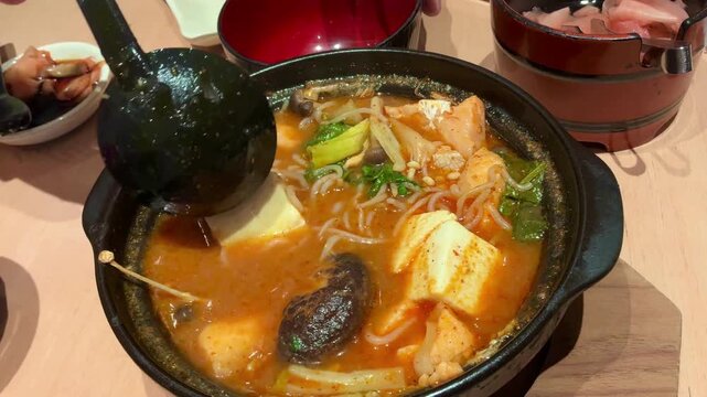 Spicy Salmon Jjigae Korean Stew with Tofu and Enoki Mushroom in Stone Pot, Hot Asian Soup