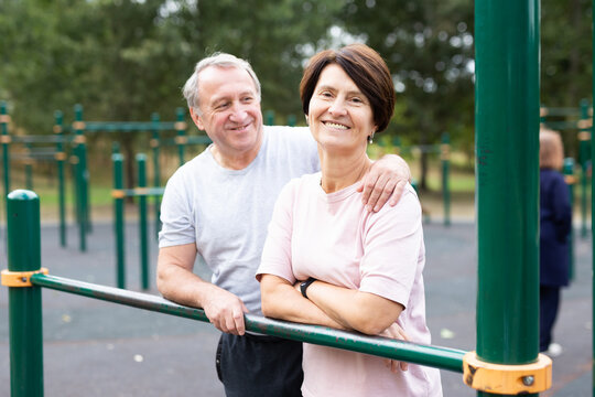 Elderly man and woman posing in open-air sports bars complex