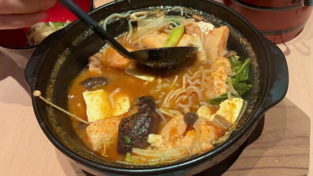 Spicy Salmon Jjigae Korean Stew with Tofu and Enoki Mushroom in Stone Pot, Hot Asian Soup