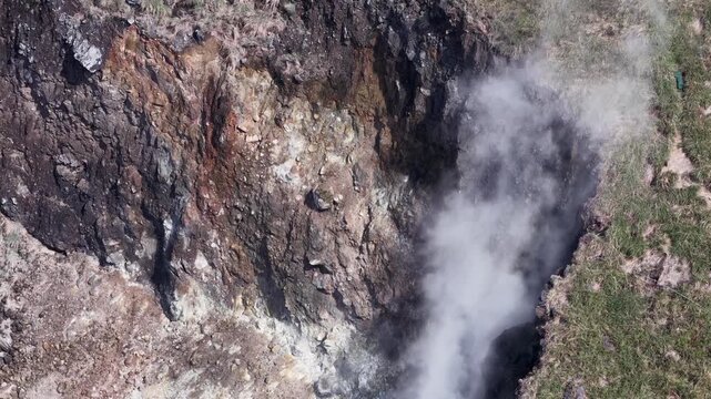 Geothermal fumarole steam venting from volcanic crater