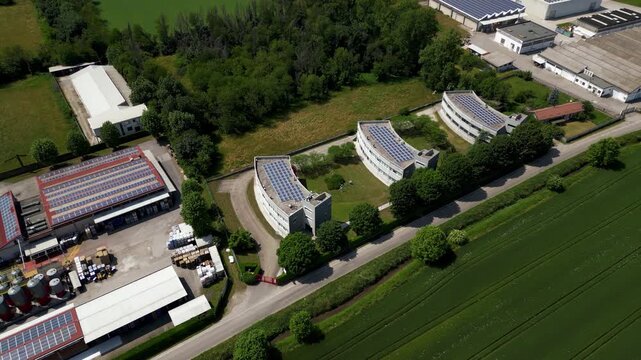 Industrial research complex with rooftop solar panels in Lombardy, Italy. Environmental monitoring and climate technology infrastructure.
