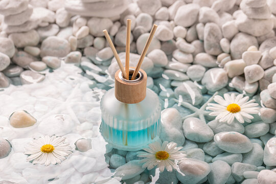 Fresh diffuser fragrance on the shore of sea ??white stones.