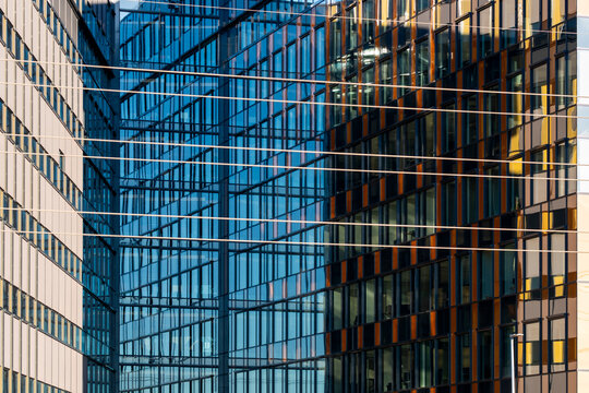 Dense reflection fills a glass building facade where windows, grid lines and urban office architecture create layered city detail