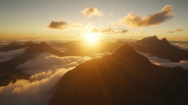 Golden sunset over mountain peaks shrouded in clouds