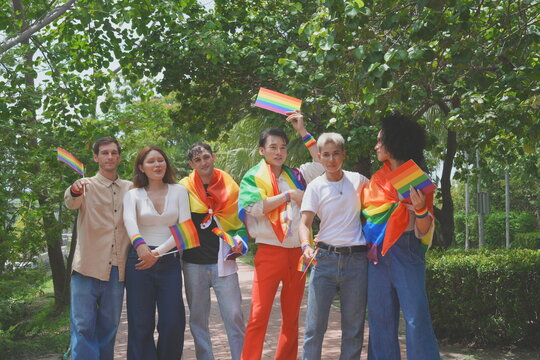 Pride and LGBTQ concept. A transgender man and his LGBTQ friends, who have a good relationship, joined the multinational parade, carrying signs and flags celebrating equal rights for all genders at Pr