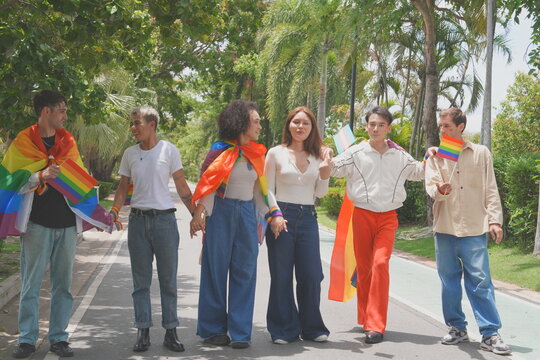 Pride and LGBTQ concept. A transgender man and his LGBTQ friends, who have a good relationship, joined the multinational parade, carrying signs and flags celebrating equal rights for all genders at Pr